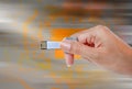 Hand holding USB data storage against light and circuit Royalty Free Stock Photo