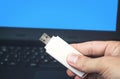 Hand holding usb flash drive on laptop background. Royalty Free Stock Photo