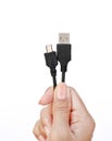 Hand holding usb to micro usb cable on white background