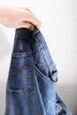 A hand holding used bluejeans on white background, recycling and reusing of worn clothes Royalty Free Stock Photo