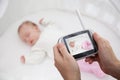 Hand holding video baby monitor for security of the baby