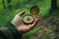 Hand holding a vintage compass in a forest, symbolizing exploration, guidance, and adventure in the natural wilderness Royalty Free Stock Photo