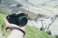 Hand holding vintage film camera with Sapa rice terraces on background, Vietnam