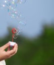 Hand holding a wand for blowing soap bubbles a Royalty Free Stock Photo