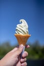 Hand holding Wasabi ice cream cone on blue sky background. Royalty Free Stock Photo