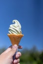 Hand holding Wasabi ice cream cone on blue sky background. Royalty Free Stock Photo