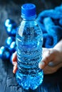 Hand holding water bottle with sweat dampened towel draped over it for hydration Royalty Free Stock Photo