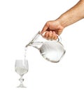 Hand holding water jug and pouring water into glass cup Royalty Free Stock Photo
