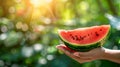 Hand holding watermelon wedge with selection of watermelons on blurred background Royalty Free Stock Photo