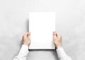 Hand holding white blank paper sheet mockup, . Royalty Free Stock Photo