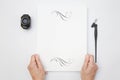 Hand holding white blank paper sheet mockup