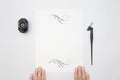 Hand holding white blank paper sheet mockup