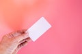 Hand holding white blank price label tag on pink background. Royalty Free Stock Photo