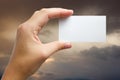 Hand holding white business card on blurred background