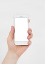 Hand holding white cellphone isolated on white clipping path inside. Online shopping. Top view. Mock up. Copy space. Template.Blan