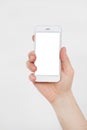 Hand holding white cellphone isolated on white clipping path inside. Online shopping. Top view. Mock up. Copy space. Template.Blan Royalty Free Stock Photo