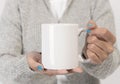 Hand holding white ceramic coffee cup. mockup for creative