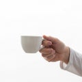 A hand is holding a white ceramic cup against a plain white background Royalty Free Stock Photo