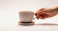 Hand holding a white ceramic mug on a coaster with a light background Royalty Free Stock Photo