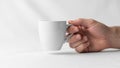 A hand is holding a white ceramic mug with a simple smooth design Royalty Free Stock Photo
