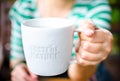 Hand holding White ceramic mug with stamp word Royalty Free Stock Photo