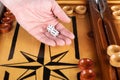 Hand holding white dice over backgammon board Royalty Free Stock Photo