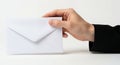 Hand Holding a White Envelope on a Neutral Background Revealing Correspondence and Communication Royalty Free Stock Photo