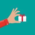 Hand holding white gift box with red bow Royalty Free Stock Photo
