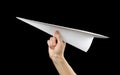 Hand holding a white paper airplane. Close up. Isolated on black background Royalty Free Stock Photo