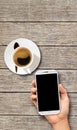 Hand holding White Smart phone on wood coffee table