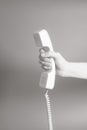 Hand holding white telephone tube on gray Royalty Free Stock Photo