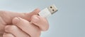 Hand holding white USB cable  on gray background Royalty Free Stock Photo