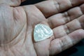 Hand holding Whtie plastic guitar plectrum. Guitar Pick