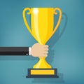 Hand holding a winner trophy cup. Royalty Free Stock Photo