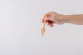 hand holding wood fork isolated on white background.