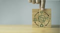 Hand holding wooden block cube with circle arrow environmental and earth icon for circular economy to sustainable development