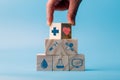 Hand holding wooden block cube which print screen health care and medical icons for healthy and wellness concept. Healthcare and