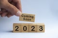 Hand holding wooden block with text - 2023 coming soon. New year concept and copy space Royalty Free Stock Photo