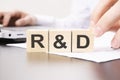 hand holding wooden cube with R and D text on table background. financial, marketing and business concepts Royalty Free Stock Photo