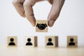 Hand holding wooden cube which drawing of hand shaking print screen on wooden cube block in front of human icon for business deal