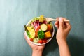 Hand holding wooden fork and eating salad Royalty Free Stock Photo