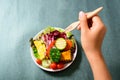 Hand holding wooden fork and eating vegetables salad Royalty Free Stock Photo