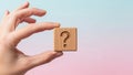 Hand Holding Wooden Question Mark Block Against Gradient Background Royalty Free Stock Photo