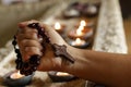 .Hand holding wooden rosary beads tightly with Jesus Christ holy cross crucifix on candle lights background/