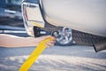 Hand holding yellow car towing strap with car