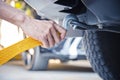 Hand holding yellow car towing strap with car