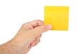 Hand holding a yellow notepaper or postit isolated