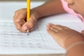 Hand is holding a yellow pencil and writing in a notebook Royalty Free Stock Photo