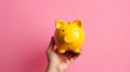 Hand holding a yellow piggy bank on pink background. Generative AI Royalty Free Stock Photo