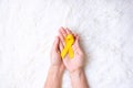 Hand holding Yellow Ribbon on white background for supporting people living and illness. September Suicide prevention day, Royalty Free Stock Photo